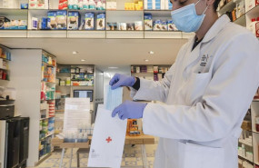 ep un farmaceutico da una mascarilla durante el reparto de mascarillas gratuitas contra el covid-19