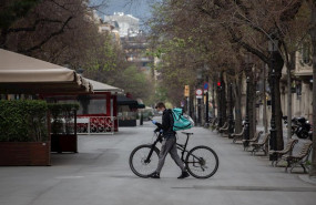 ep un trabajador de deliveroo en bicicleta por una calle de barcelona vacia durante el primer dia