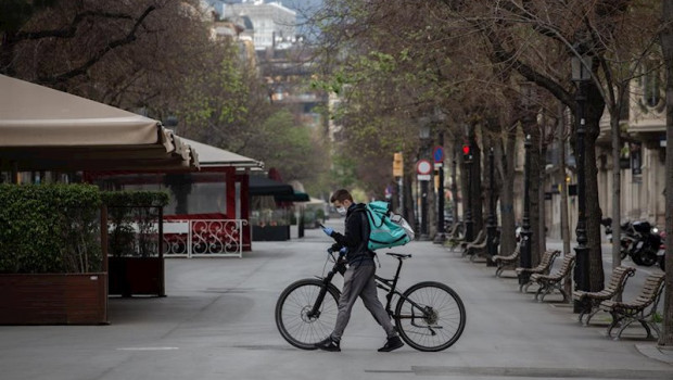 ep un trabajador de deliveroo en bicicleta por una calle de barcelona vacia durante el primer dia