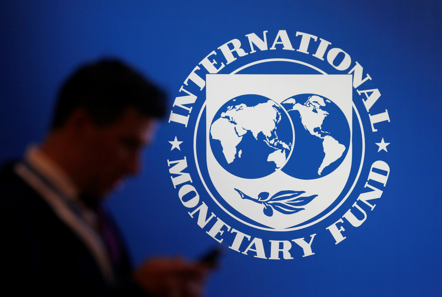 un homme se tient pres d un logo du fmi 20241024213424 