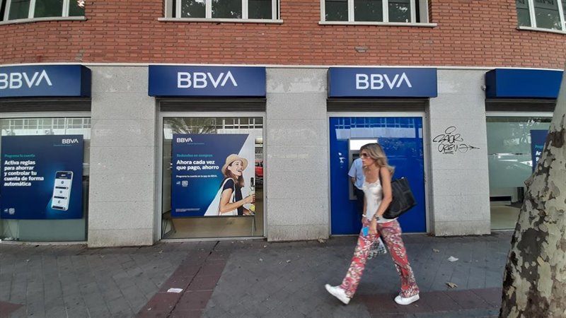 ep una mujer pasa una oficina bancaria con el nuevo logo del bbva en madrid
