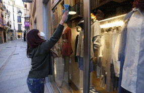 ep una mujer limpia el escaparate de su tienda en granada