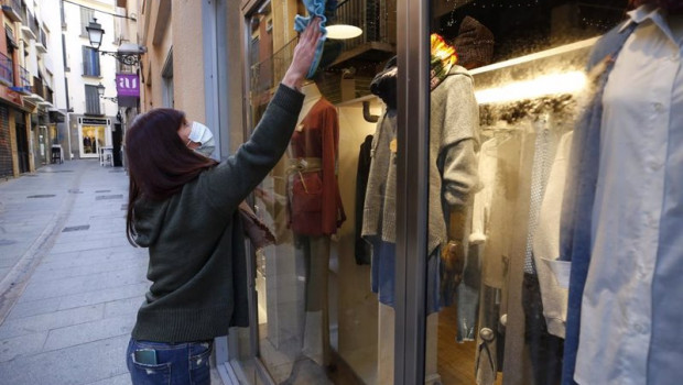 ep una mujer limpia el escaparate de su tienda en granada
