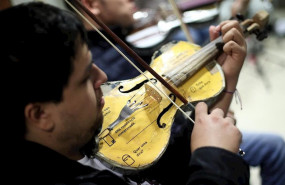 ep un joven de la orquesta de instrumentos reciclados de cateura toca el violin durante un ensayo en