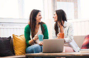 women chatting while enjoying a cup of coffee 
