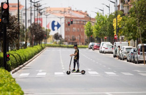 ep archivo   un joven cruza con un patinete electrico bajo el sol en la calle hellin a 11 de julio