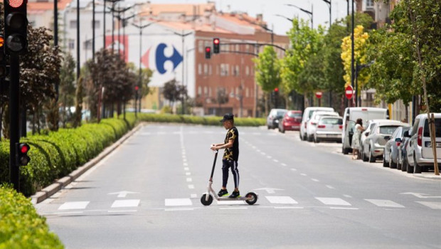 ep archivo   un joven cruza con un patinete electrico bajo el sol en la calle hellin a 11 de julio