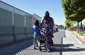 ep una madre y su hijo empujan el carrito de un bebe en un parque de madrid