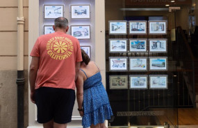 ep archivo   dos personas observan los anuncios de viviendas en una inmobiliaria
