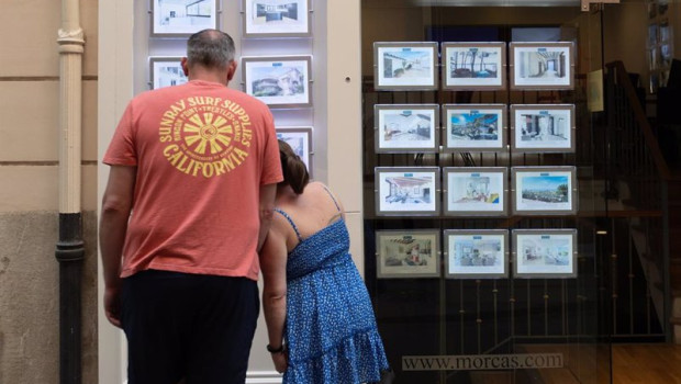 ep archivo   dos personas observan los anuncios de viviendas en una inmobiliaria
