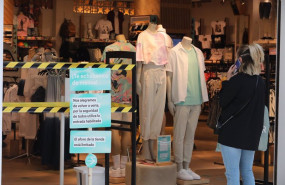 ep archivo   una mujer habla por telefono en la entrada a una tienda de ropa del centro plaza norte