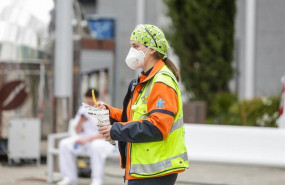 ep una trabajadora sanitaria protegida con mascarilla sostiene un tentempie en las inmediaciones del