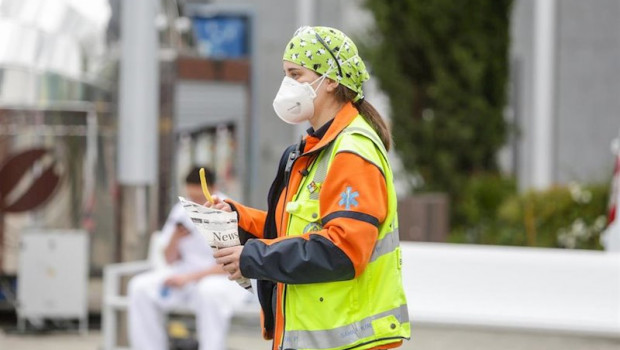 ep una trabajadora sanitaria protegida con mascarilla sostiene un tentempie en las inmediaciones del