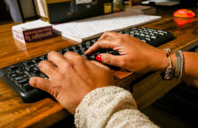 ep archivo   unas manos de mujer escriben en el teclado de un ordenador sobre una mesa de madera