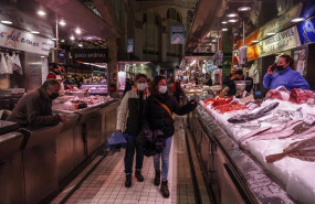 ep dos personas pasan por un puesto de pescado en el mercado central de valencia a 24 de marzo de
