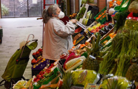 ep una senora con mascarilla comprando en un mercado