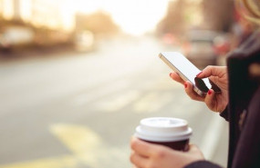 ep una persona mira su movil mientras toma un cafe