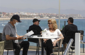 ep varias personas disfrutan en la terraza de un bar junto a la playa despues de que el ministerio