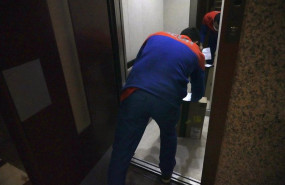 ep archivo   un repartidor dejando un paquete en el ascensor de un edificio