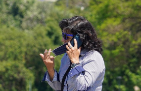 ep una mujer se quita la mascarilla para hablar por telefono mientras pasea por el puente de triana