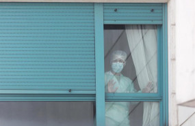 ep una trabajadora protegida con mascarilla se asoma por una de las ventanas de la residencia orpea