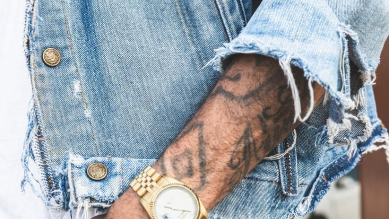 1593108101 person in round gold colored watch 2923824