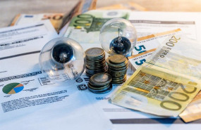 ep archivo   dos bombillas sobre billetes monedas y facturas en imagen de archivo