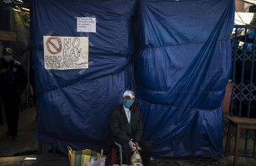 ep un vendedor ambulante ante la entrada de un mercadillo cerrado por el coronavirus