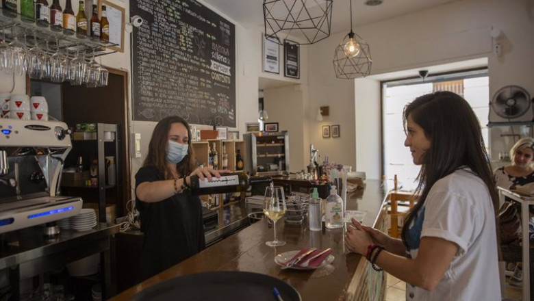 Una camarera sirve una copa de vino a una clienta en la barra del bar en Sevilla | María José López - Europa Press - Archivo ep una camarera sirve una copa de vino a una clienta en la barra del bar en sevilla