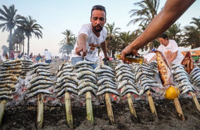 ep archivo   un espetero ante una barca con espetos de sardinas