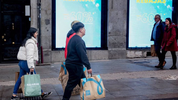 ep varias personas caminan por una calle comercial de madrid tras comprar en las rebajas