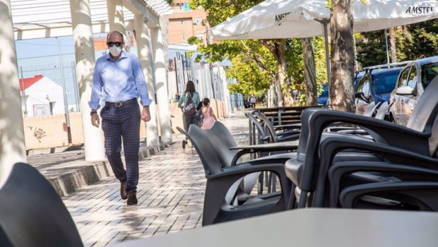 ep un hombre camina junto a la terraza de un bar