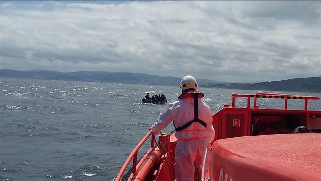 Un operario de Salvamento Marítimo y una patera al fondo | SALVAMENTO MARÍTIMO ep un operariosalvamento maritimouna paterafondo