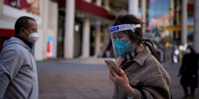 une femme portant un masque de protection et un ecran facial marche a shanghai en chine 20240602133243 