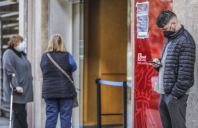 ep archivo   un joven mira su telefono movil mientras espera para entrar en una oficina del sepe