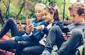 kids on phones in park 