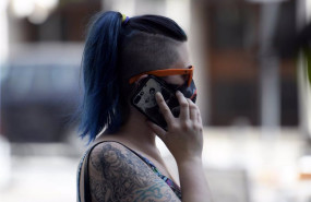 ep una mujer con mascarilla hablando por telefono