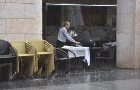 ep archivo   un camarero recogiendo una mesa en una terraza