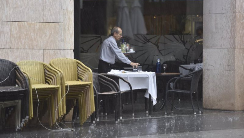 ep archivo   un camarero recogiendo una mesa en una terraza