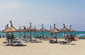 ep turistas en hamacas bajo las sombrillas de la playa de palma