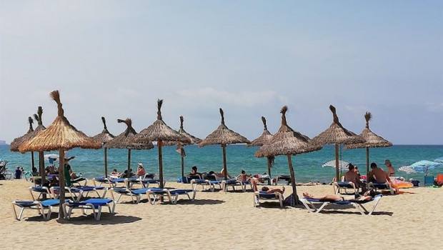 ep turistas en hamacas bajo las sombrillas de la playa de palma