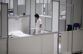 ep un profesional sanitario frente a una cama vacia en el interior del hospital de campana de ifema