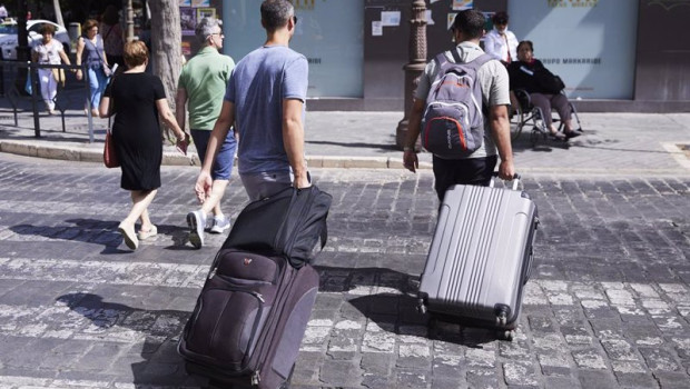 ep archivo   dos turistas con maletas cruzan un paso de peatones