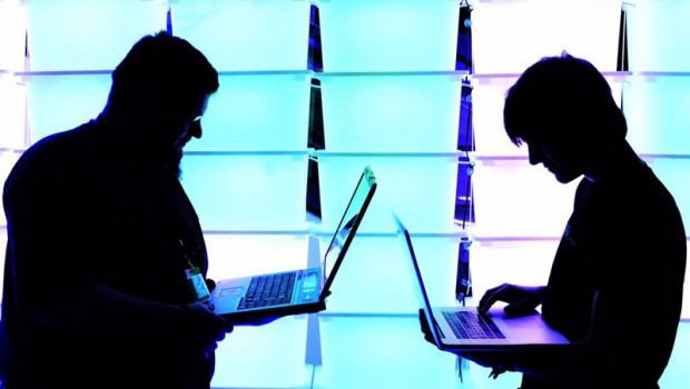 ep archivo   participant hold their laptops in front of an illuminated wall at the annual chaos