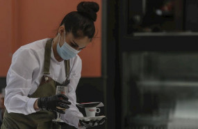 ep una camarera con mascarilla y guantes atiende un bar