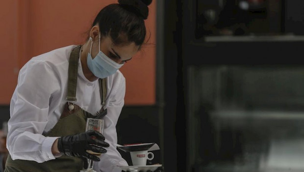 ep una camarera con mascarilla y guantes atiende un bar