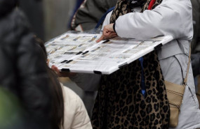 ep una personas compra un decimo de loteria de navidad a una vendedora ambulante