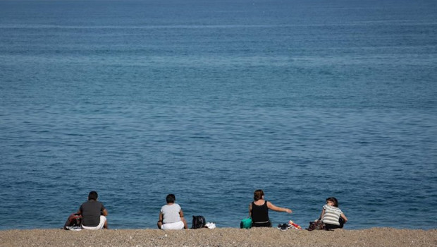 ep varias personas sentadas en la playa de la barceloneta