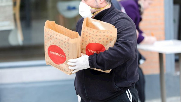 ep un hombre protegido con una mascarilla y guantes de latex recoge varios menus infantiles de