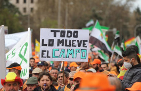 ep varios manifestantes con gorras naranjas con una pancarta que reza todo lo mueve el campo durante
